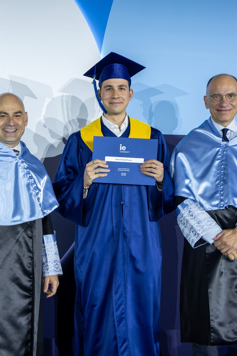 Artie Parada in cap and gown at his IE University graduation, holding his diploma